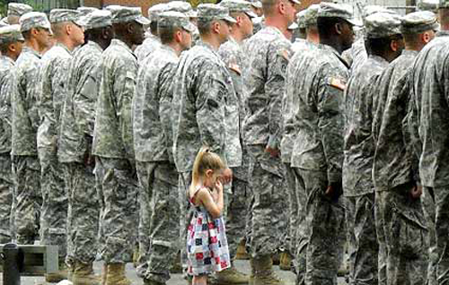 Paige Bennethum, 4, holds her daddy's hand as he lines up in formation before heading to Iraq. (Credit: Abby Bennethum)